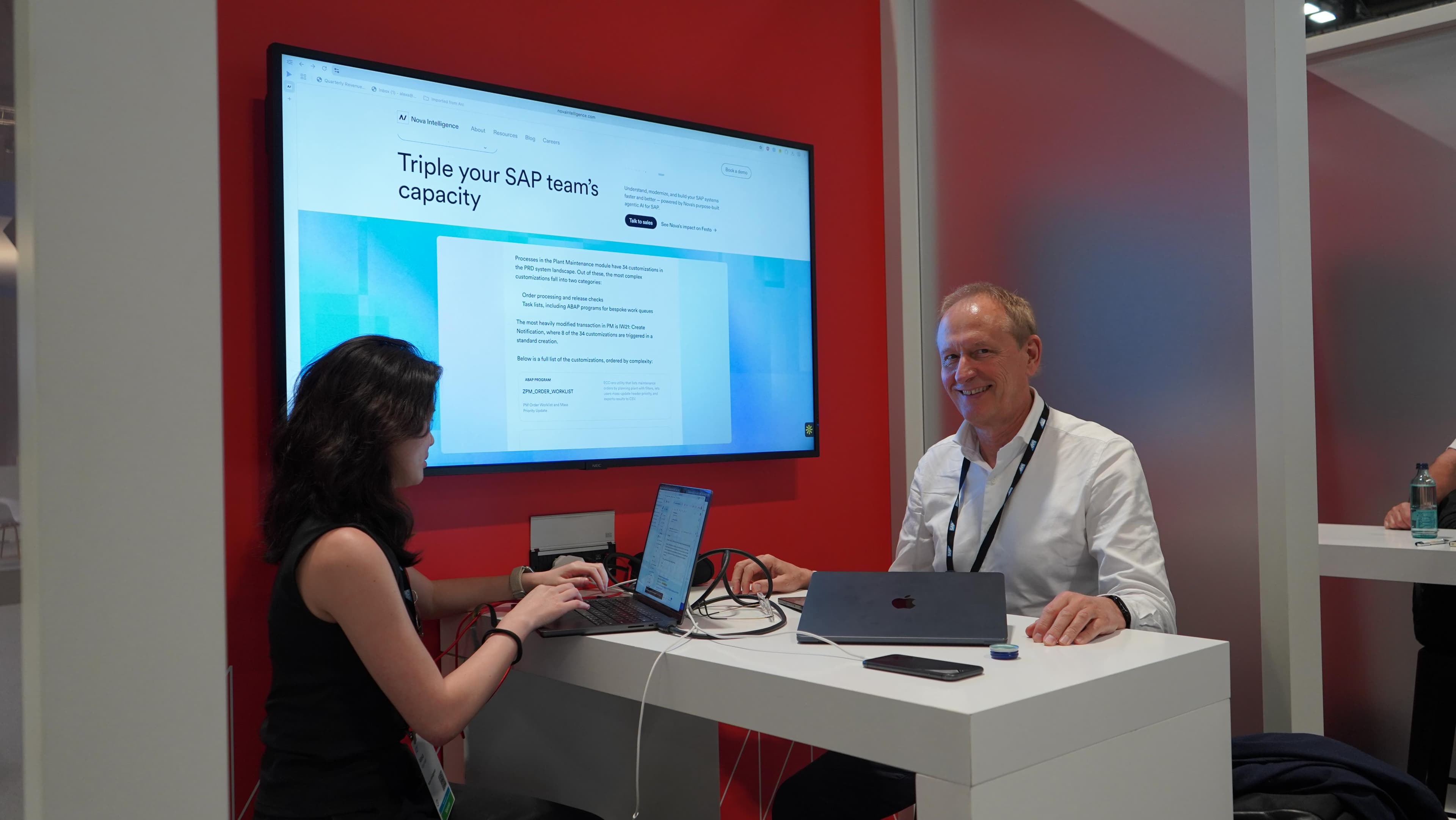 A Nova team member demoing the platform to a visitor at the company's SAP Sapphire booth